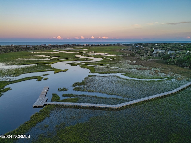 aerial view at dusk featuring a water view