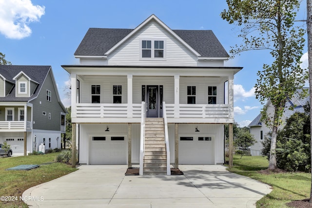 view of front of house featuring a garage, covered porch, and a front lawn