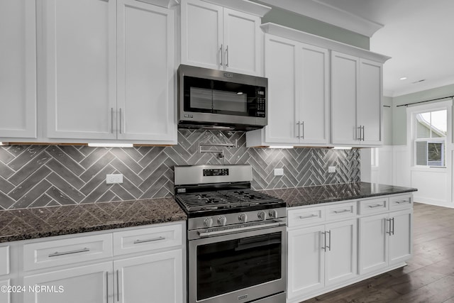 kitchen featuring white cabinetry, appliances with stainless steel finishes, dark hardwood / wood-style floors, and dark stone countertops