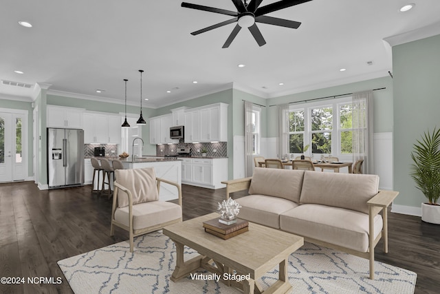 living room with dark hardwood / wood-style flooring, sink, ornamental molding, and ceiling fan