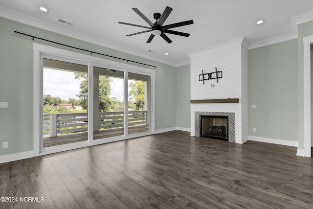 unfurnished living room featuring ceiling fan, a large fireplace, ornamental molding, and dark hardwood / wood-style floors