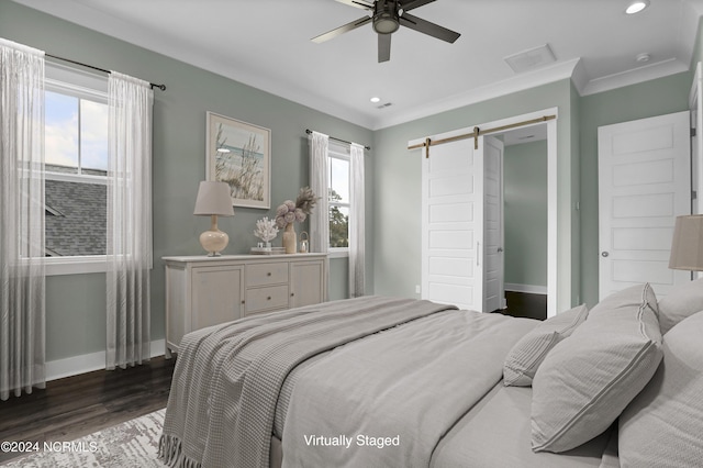 bedroom featuring crown molding, wood-type flooring, a closet, ceiling fan, and a barn door