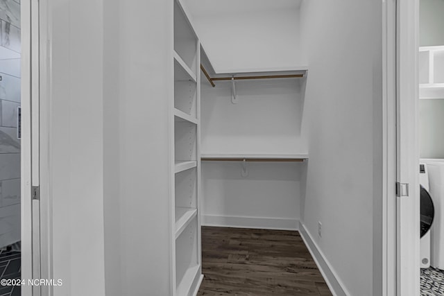 spacious closet with dark hardwood / wood-style floors and washer / clothes dryer