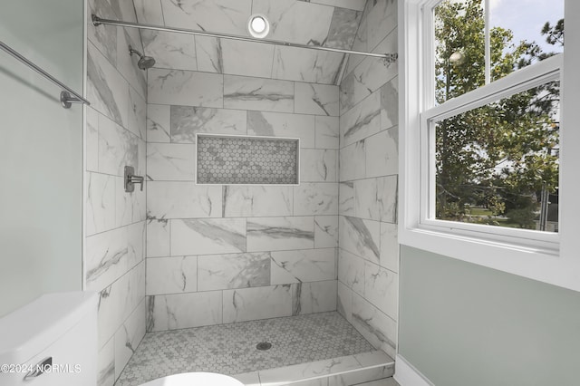 bathroom featuring toilet and tiled shower