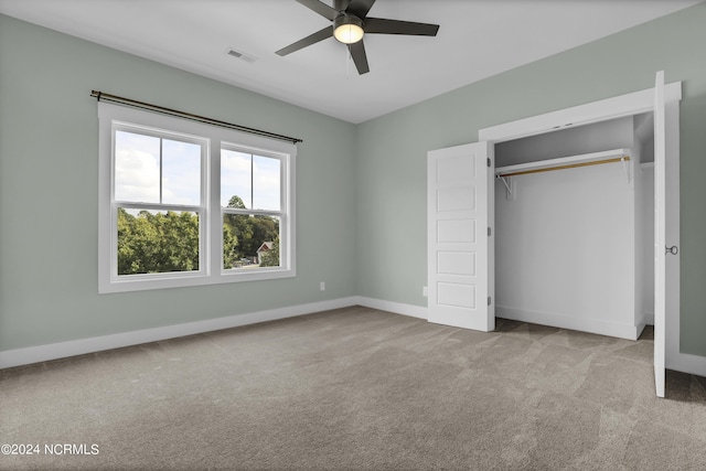 unfurnished bedroom featuring light carpet, ceiling fan, and a closet