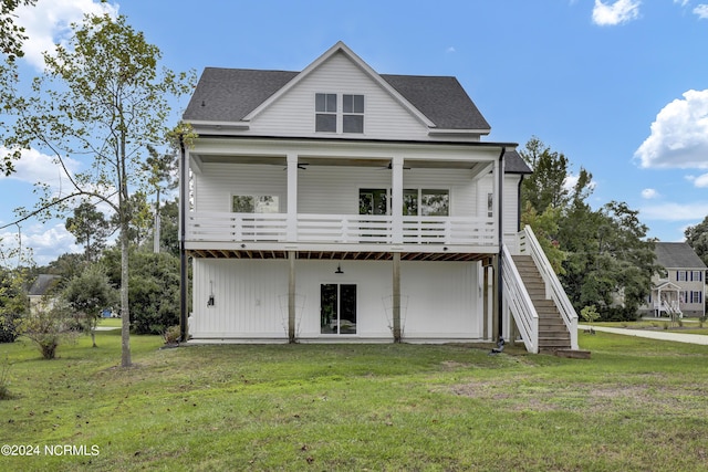 back of property with a wooden deck, a yard, and ceiling fan