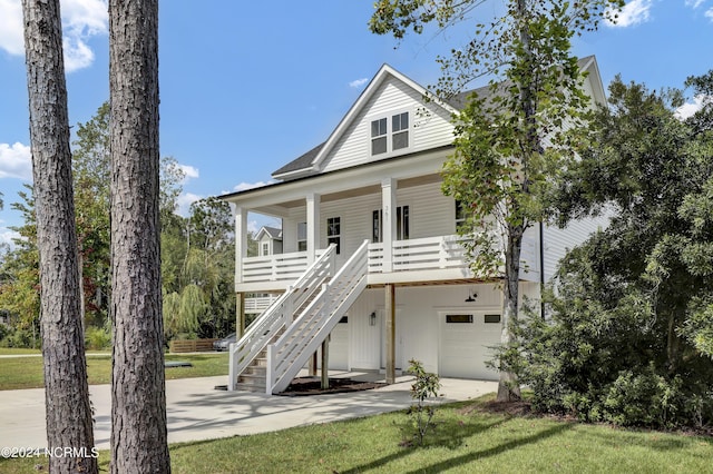 beach home featuring a garage, covered porch, and a front lawn