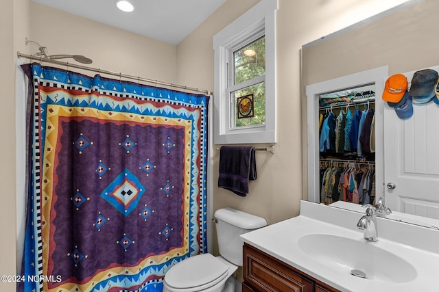 bathroom featuring a shower with shower curtain, vanity, and toilet