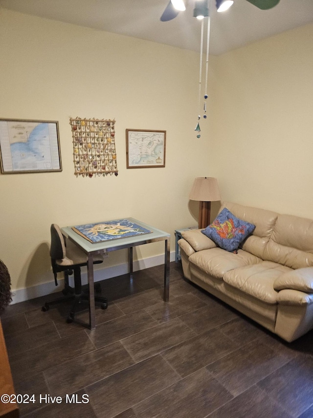 living room featuring ceiling fan and dark wood-type flooring