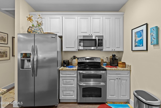 kitchen featuring white cabinetry, light stone countertops, and stainless steel appliances