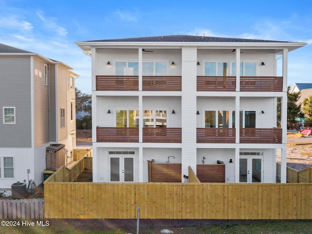 rear view of house featuring french doors, a balcony, and central AC unit