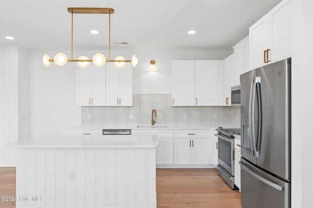 kitchen featuring white cabinets, pendant lighting, stainless steel appliances, and sink