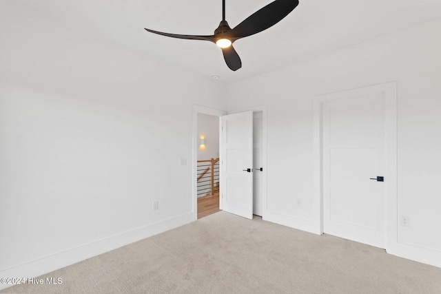 unfurnished bedroom featuring ceiling fan and light carpet