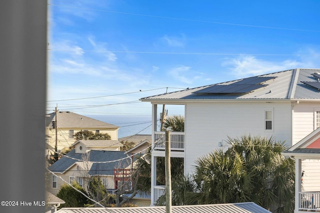 view of side of property featuring a balcony and solar panels