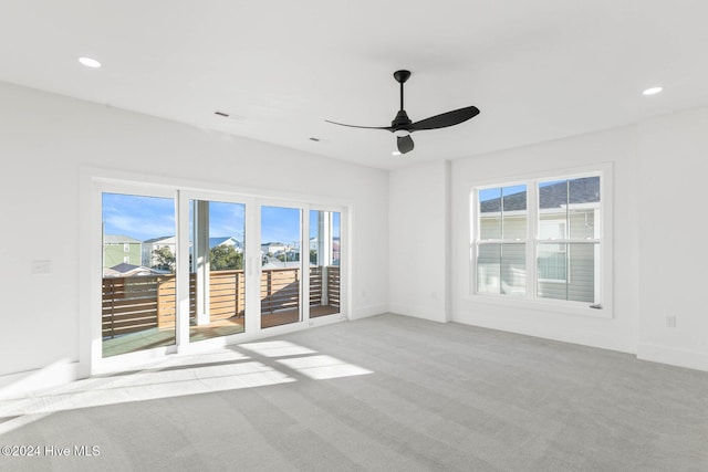 carpeted spare room with ceiling fan and a healthy amount of sunlight