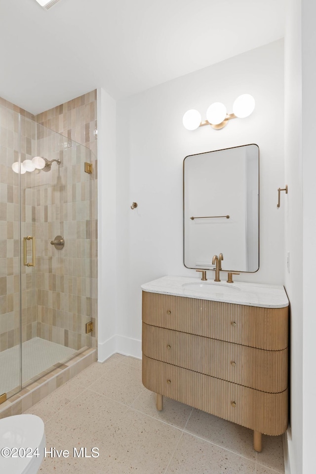 bathroom featuring vanity, toilet, and a shower with shower door