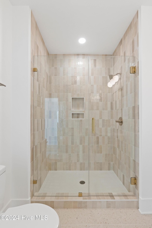 bathroom featuring toilet and an enclosed shower