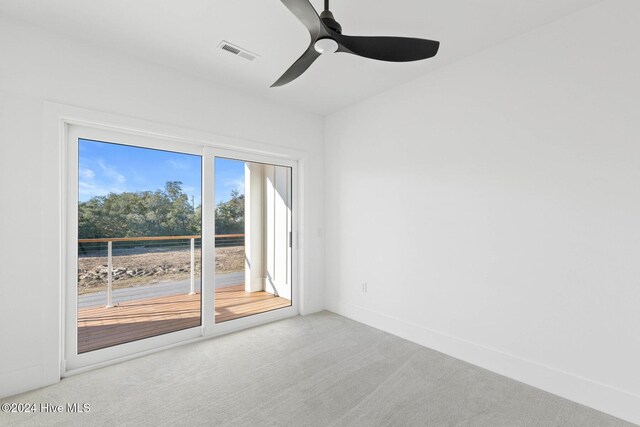 carpeted spare room featuring ceiling fan