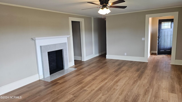 unfurnished living room featuring ornamental molding, hardwood / wood-style floors, ceiling fan, and a fireplace