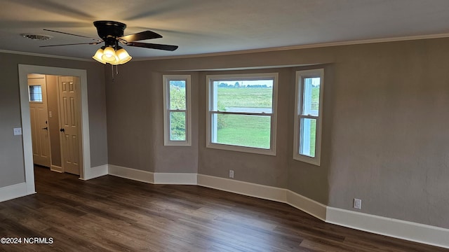 empty room with ornamental molding, dark wood-type flooring, and ceiling fan