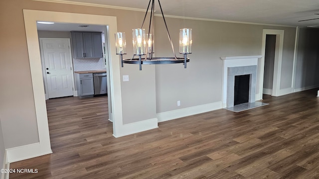 kitchen featuring dishwasher, a tile fireplace, dark hardwood / wood-style floors, backsplash, and decorative light fixtures