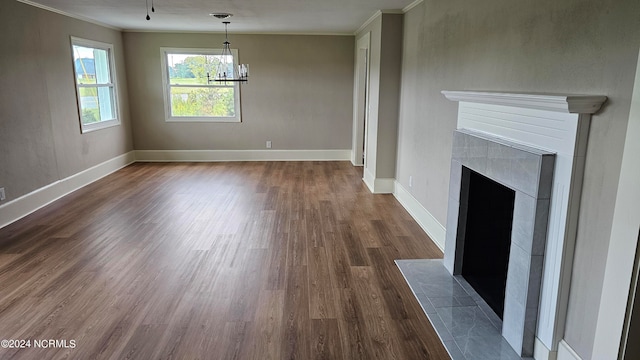 unfurnished living room with ornamental molding, a chandelier, and dark hardwood / wood-style flooring