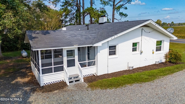 rear view of property featuring a sunroom