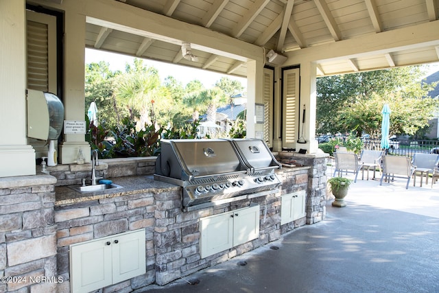 view of patio with an outdoor kitchen, sink, and a grill