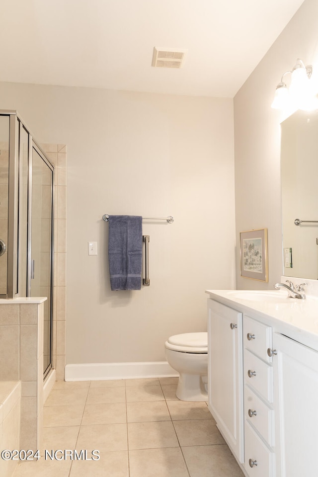 bathroom with vanity, tile patterned flooring, toilet, and an enclosed shower