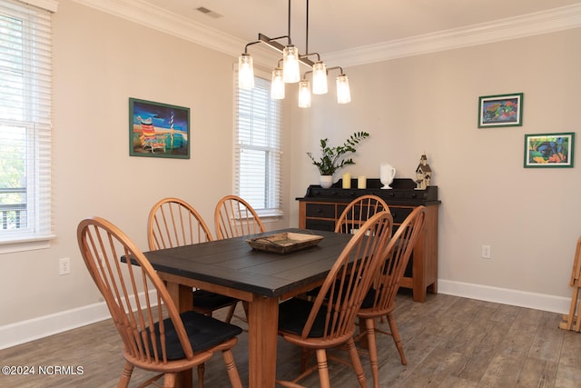 dining space featuring crown molding, a wealth of natural light, a chandelier, and dark hardwood / wood-style flooring