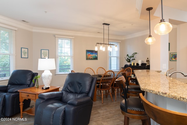 dining room featuring crown molding, hardwood / wood-style floors, and sink