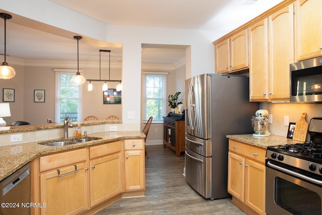 kitchen with light brown cabinets, hanging light fixtures, sink, light hardwood / wood-style flooring, and appliances with stainless steel finishes