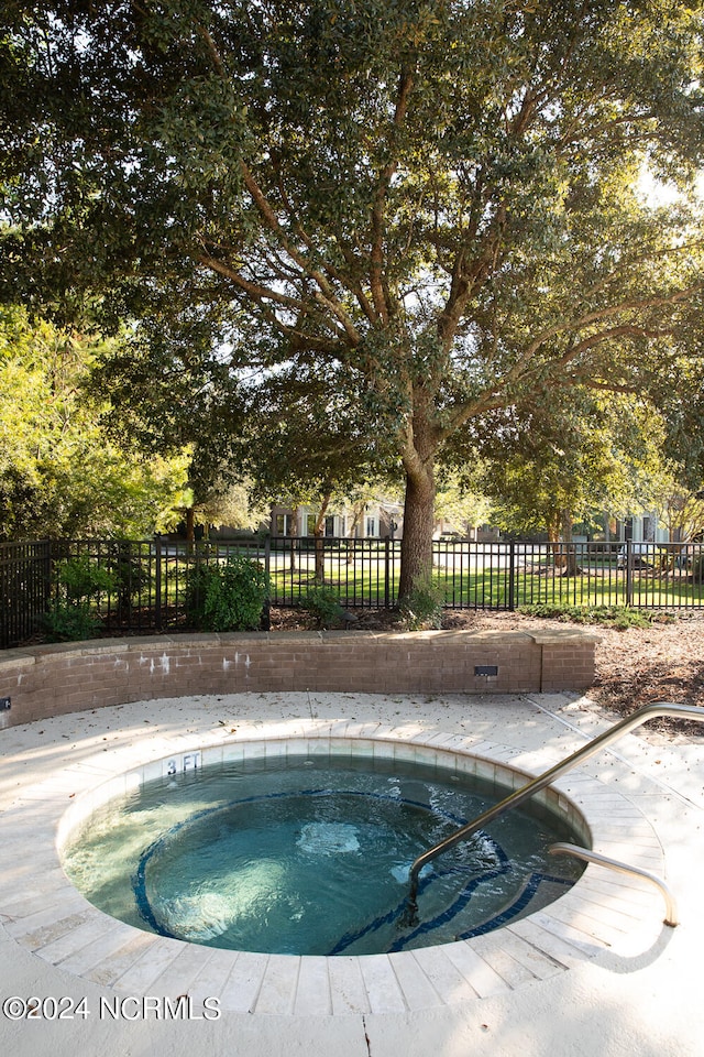 view of swimming pool with an in ground hot tub