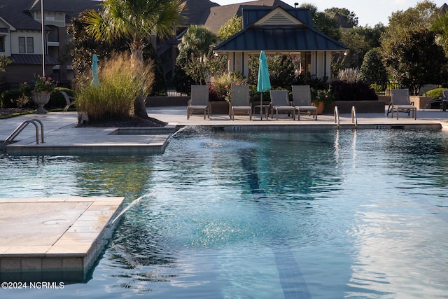 view of pool with a patio and pool water feature