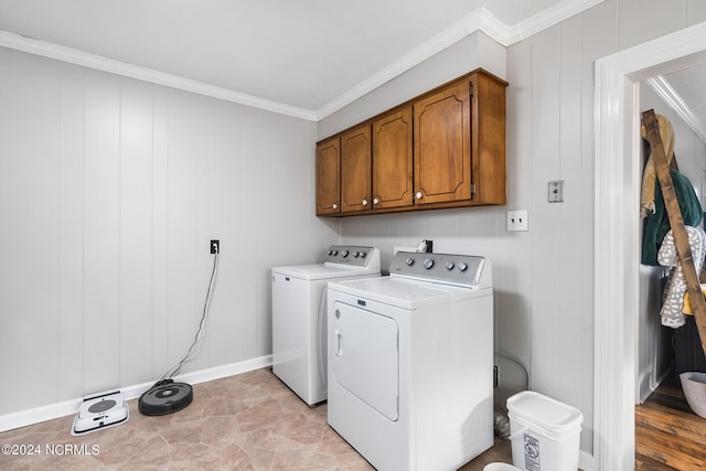 laundry area with crown molding, separate washer and dryer, wood walls, and cabinets