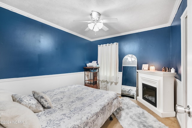 bedroom with ceiling fan, a textured ceiling, and crown molding