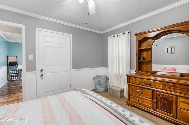 bedroom featuring ceiling fan, a textured ceiling, a closet, light carpet, and crown molding