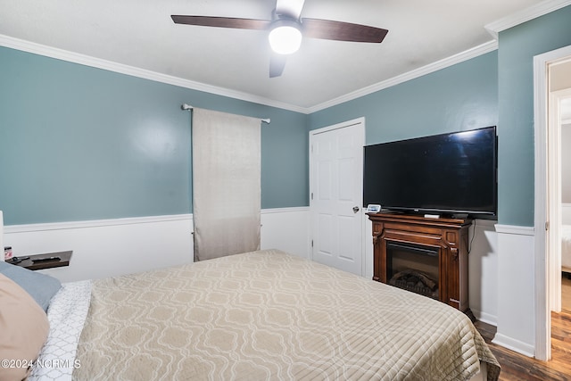 bedroom with wood-type flooring, crown molding, and ceiling fan