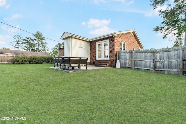 rear view of property with french doors, a lawn, and a patio area