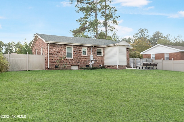 rear view of house with a lawn and a patio area