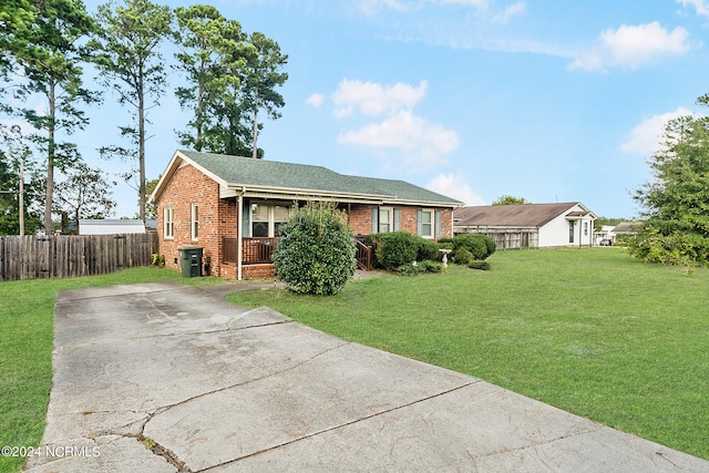 ranch-style home featuring a front lawn and covered porch