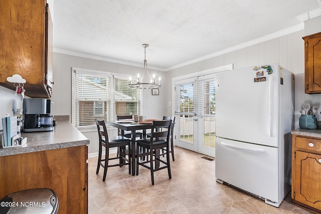 dining room with a wealth of natural light, a chandelier, and crown molding