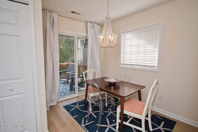 dining area with hardwood / wood-style flooring and a notable chandelier