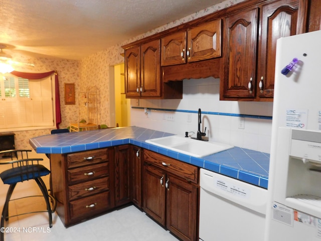 kitchen featuring tile counters, white appliances, sink, and ceiling fan