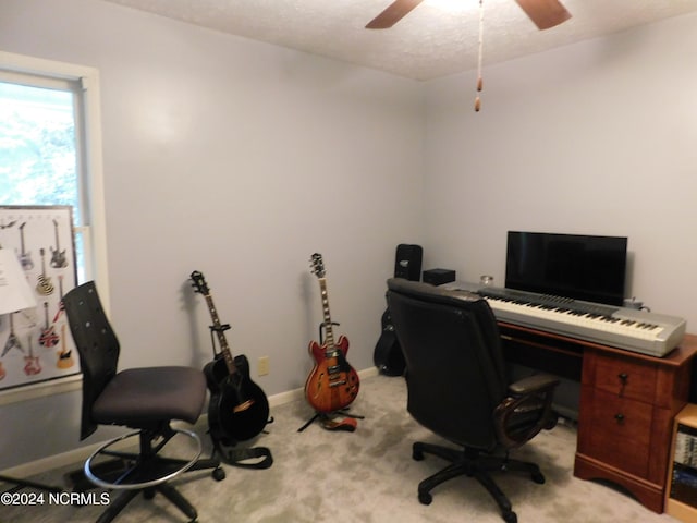 carpeted home office with a textured ceiling and ceiling fan