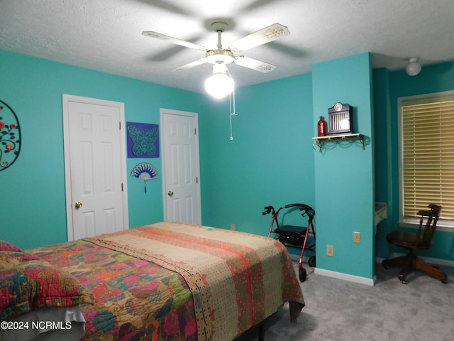 carpeted bedroom featuring a textured ceiling and ceiling fan