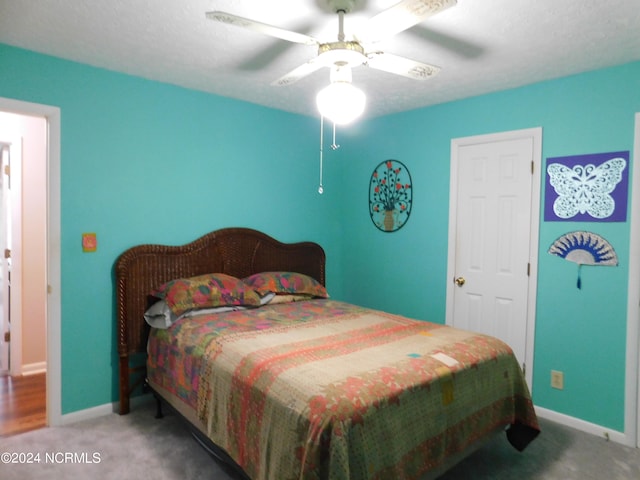 bedroom with ceiling fan, carpet floors, and a textured ceiling