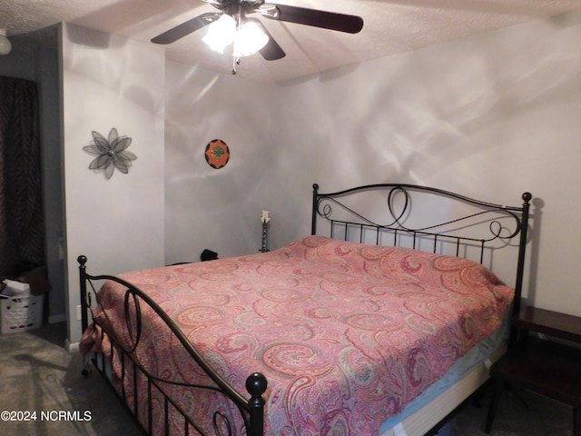 bedroom featuring ceiling fan, a textured ceiling, and carpet