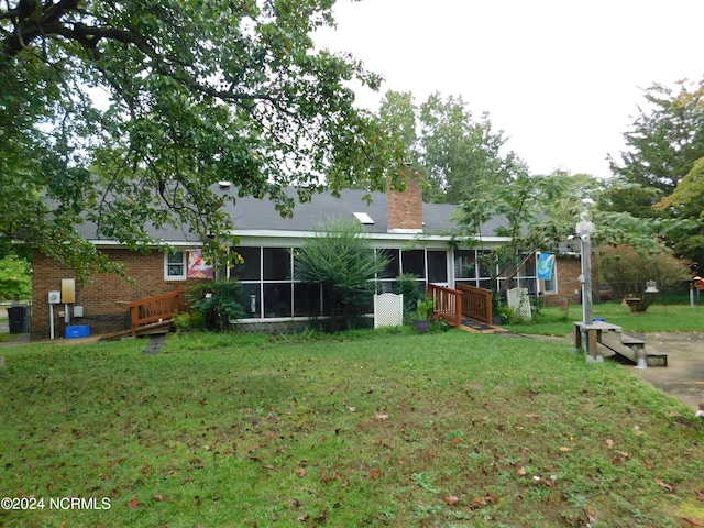 back of house with a sunroom and a yard