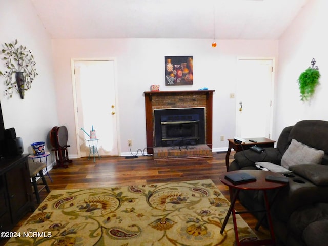 living room featuring a fireplace and dark wood-type flooring